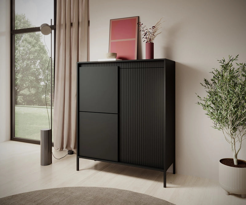 Wysoka komoda w modnym czarnym kolorze na tel nowoczesnej ścianki