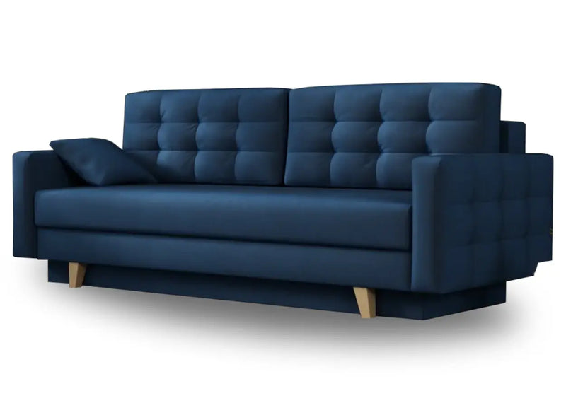 Granatowa sofa z pikowanymi poduszkami i naturalnymi nóżkami 