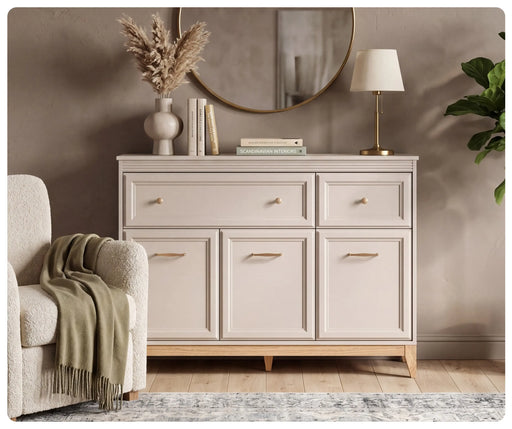 Komoda Windsor 01 w kolorze kaszmir w eleganckim salonie – ozdobne listwy MDF na frontach, uchwyty w kolorze miedzi i nogi z litego drewna dębowego